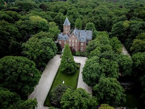 Une vue aérienne d’un grand bâtiment historique, entouré d’une végétation luxuriante.