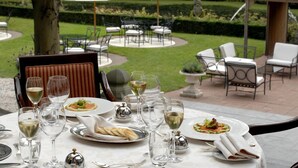 An outdoor dining area with tables, chairs, and umbrellas. - Kasteel de Wittenburg (Wassenaar)