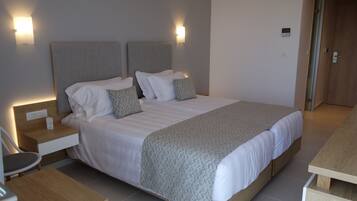 Ein modernes Hotelzimmer mit einem großen Bett, Nachttischen und Wandleuchten.