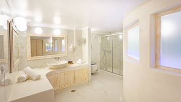 Un baño moderno con un espejo grande, un lavabo redondo, cabina de ducha y un inodoro.