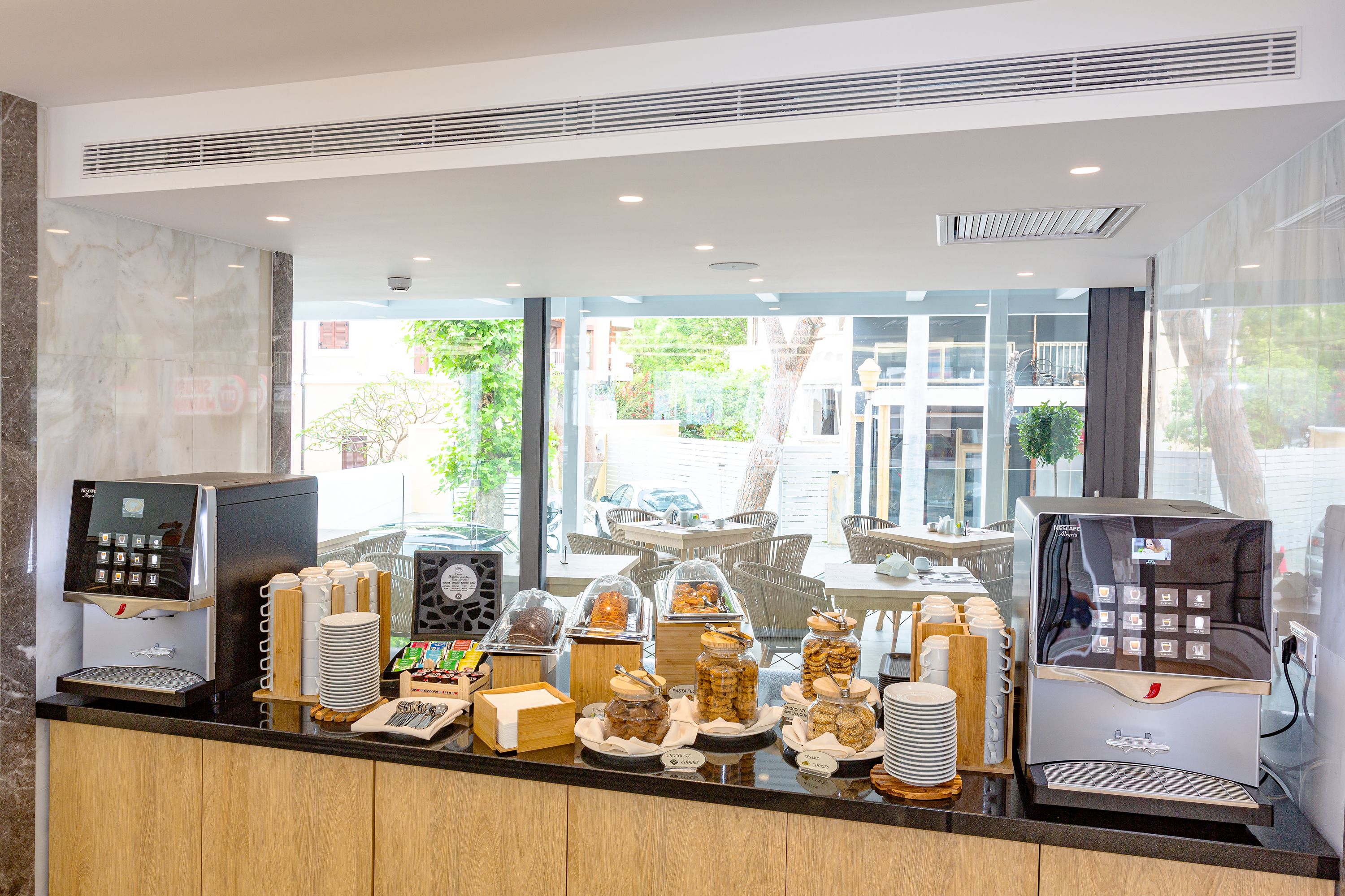 Ein Frühstücksbuffet mit verschiedenen Speisen und Kaffeeautomaten.