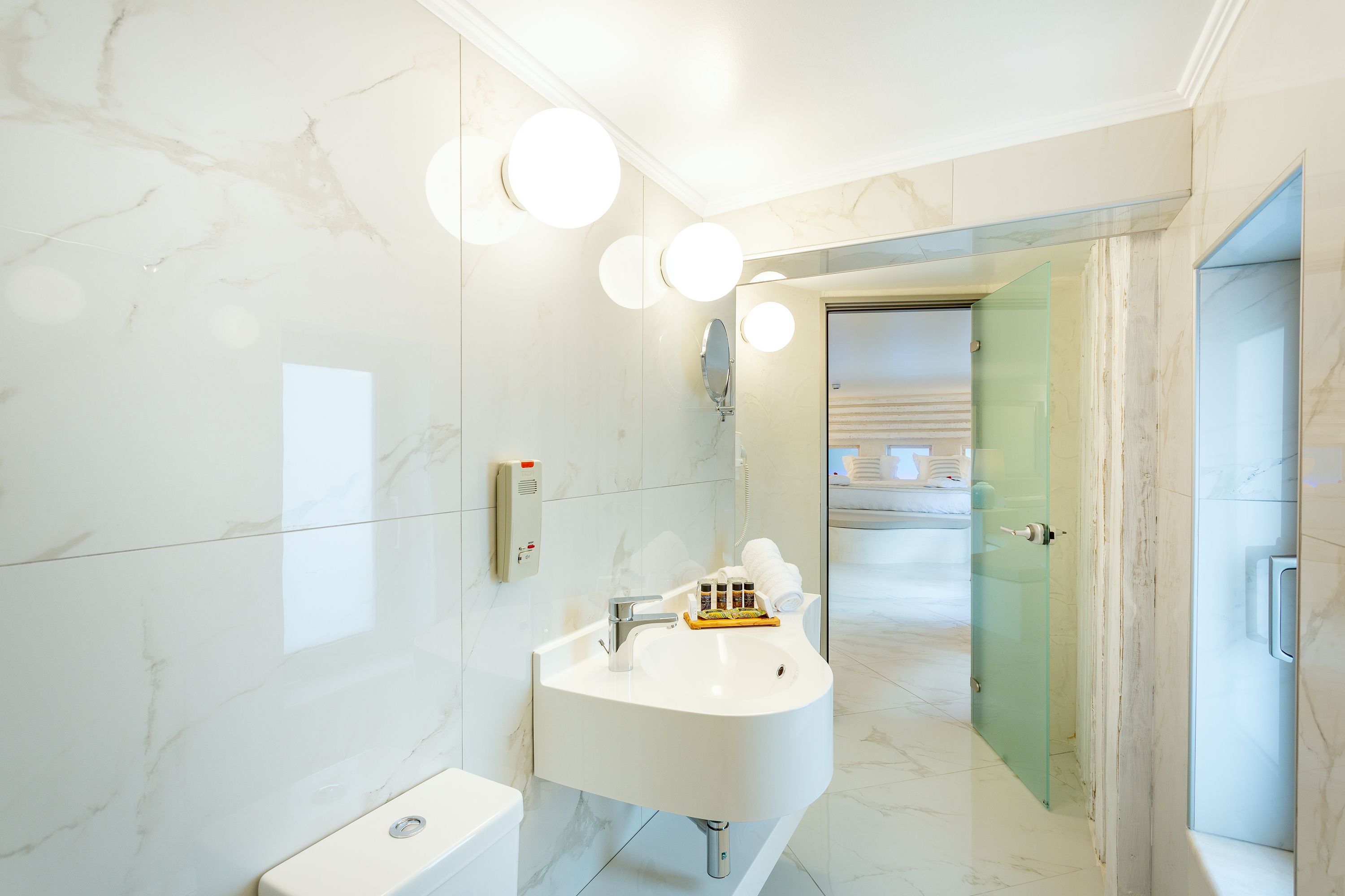 A modern bathroom with a white sink, a mirror, and a glass shower enclosure.