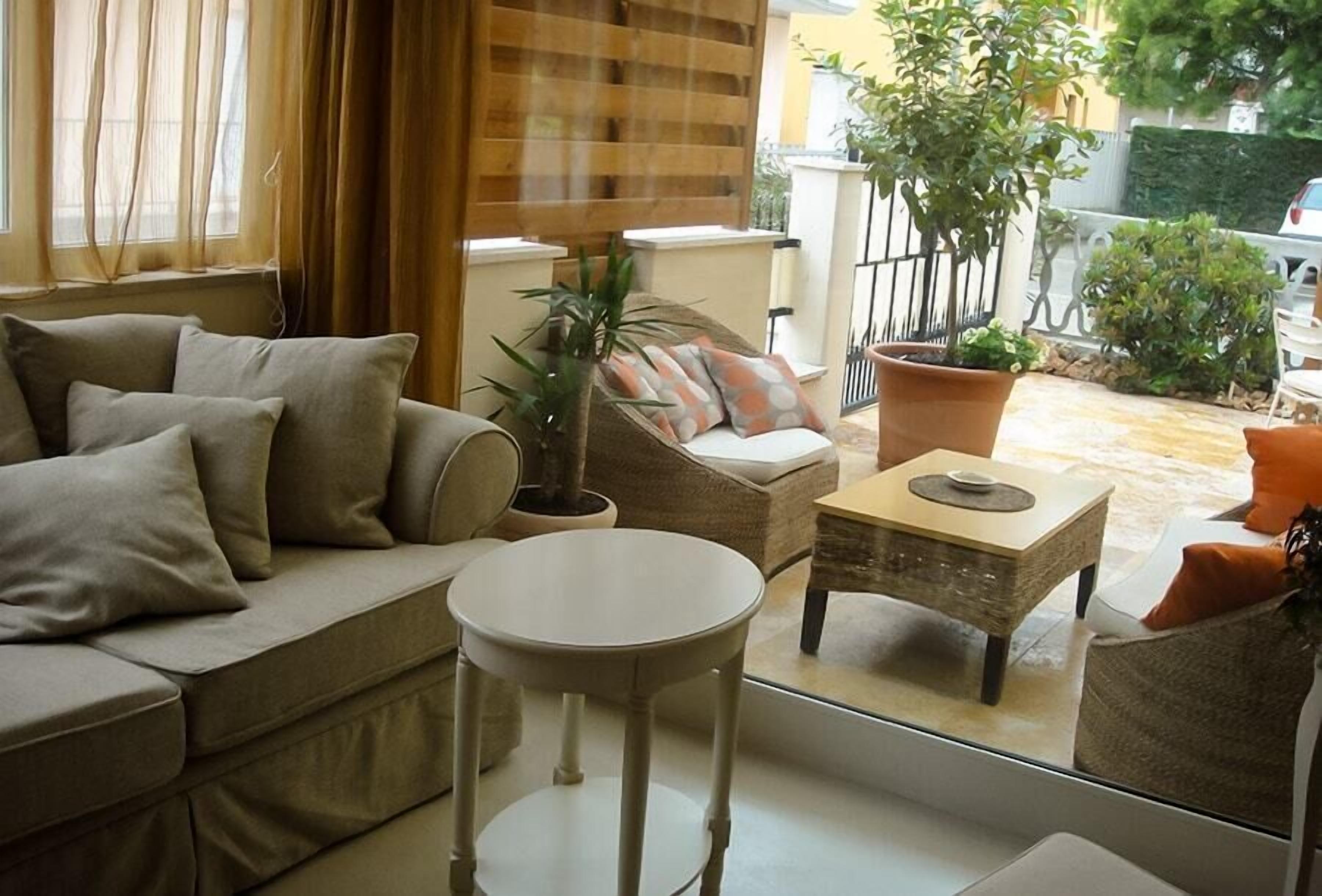 A cozy living room with a sofa, a round table, and a potted plant.
