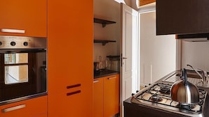 Una cocina con armarios color naranja, una estufa y un horno.