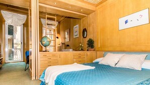 Ein Schlafzimmer mit einem großen Bett, einem Holzschrank, einem Globus und einem Spiegel.