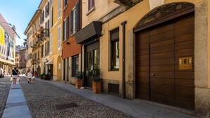 Eine Kopfsteinpflasterstraße mit Gebäuden, die große Holztüren und ein Schild für ein Restaurant haben.