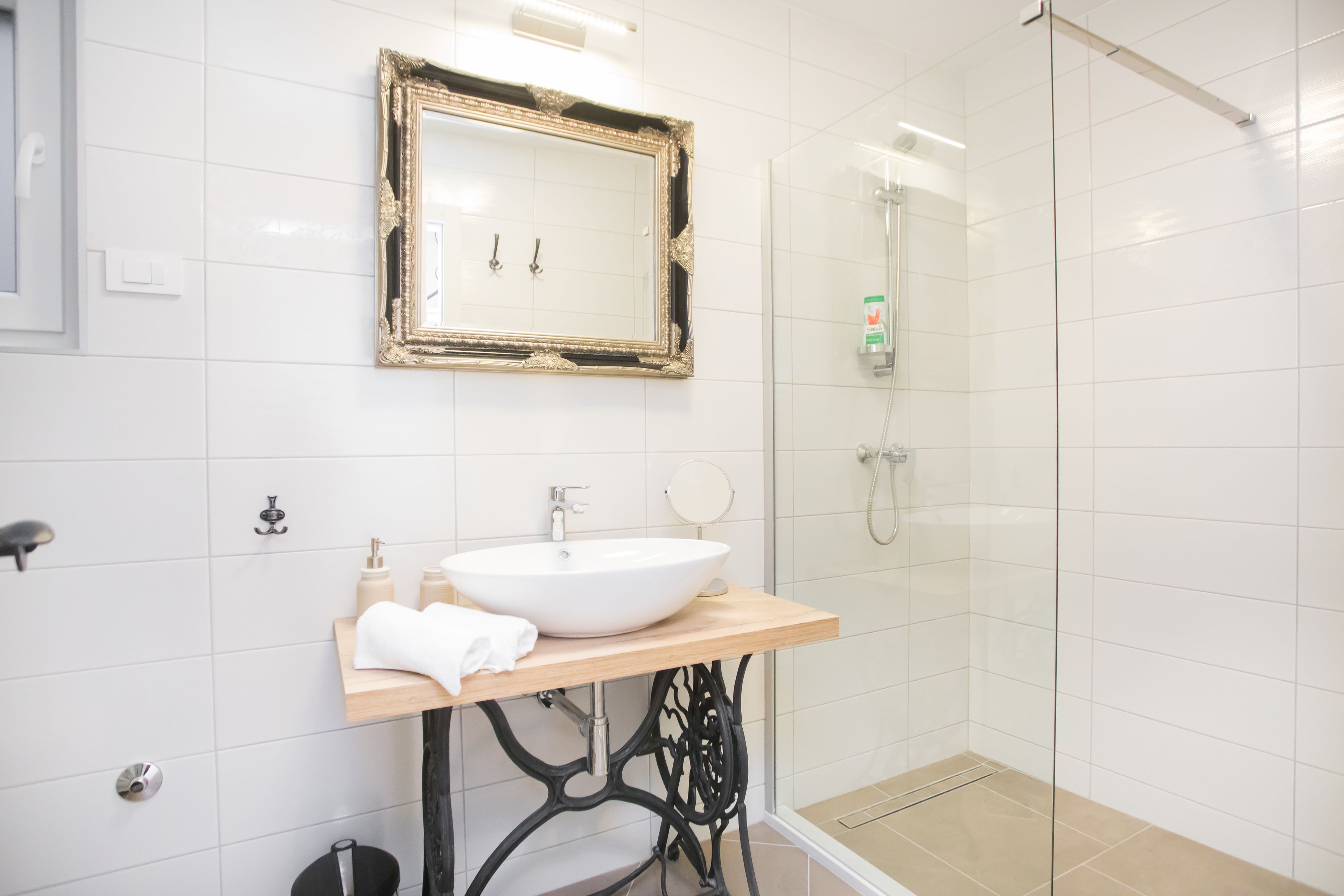 A bathroom with a white sink, a mirror, and a shower.