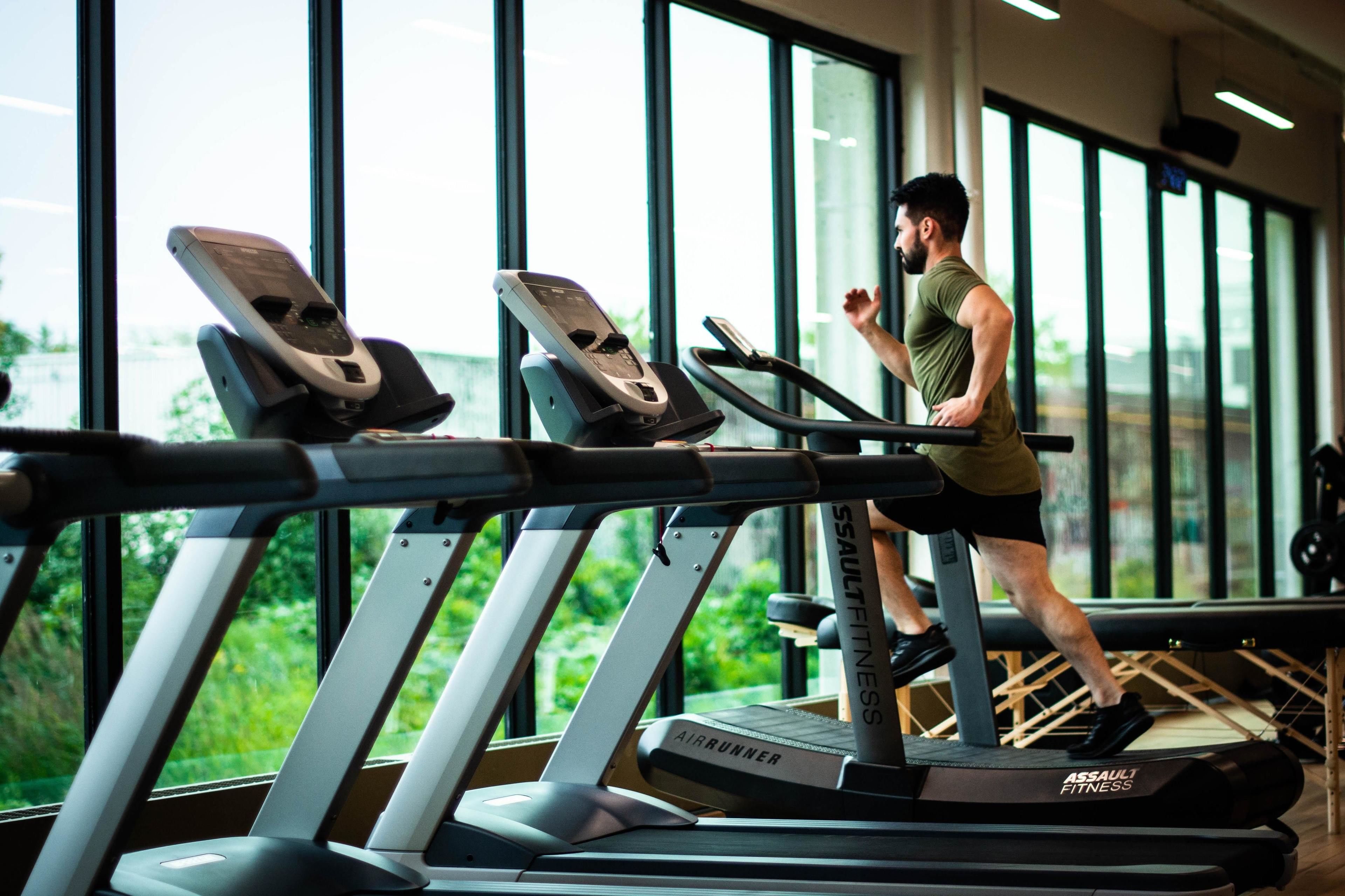 A gym with treadmills and a large window.