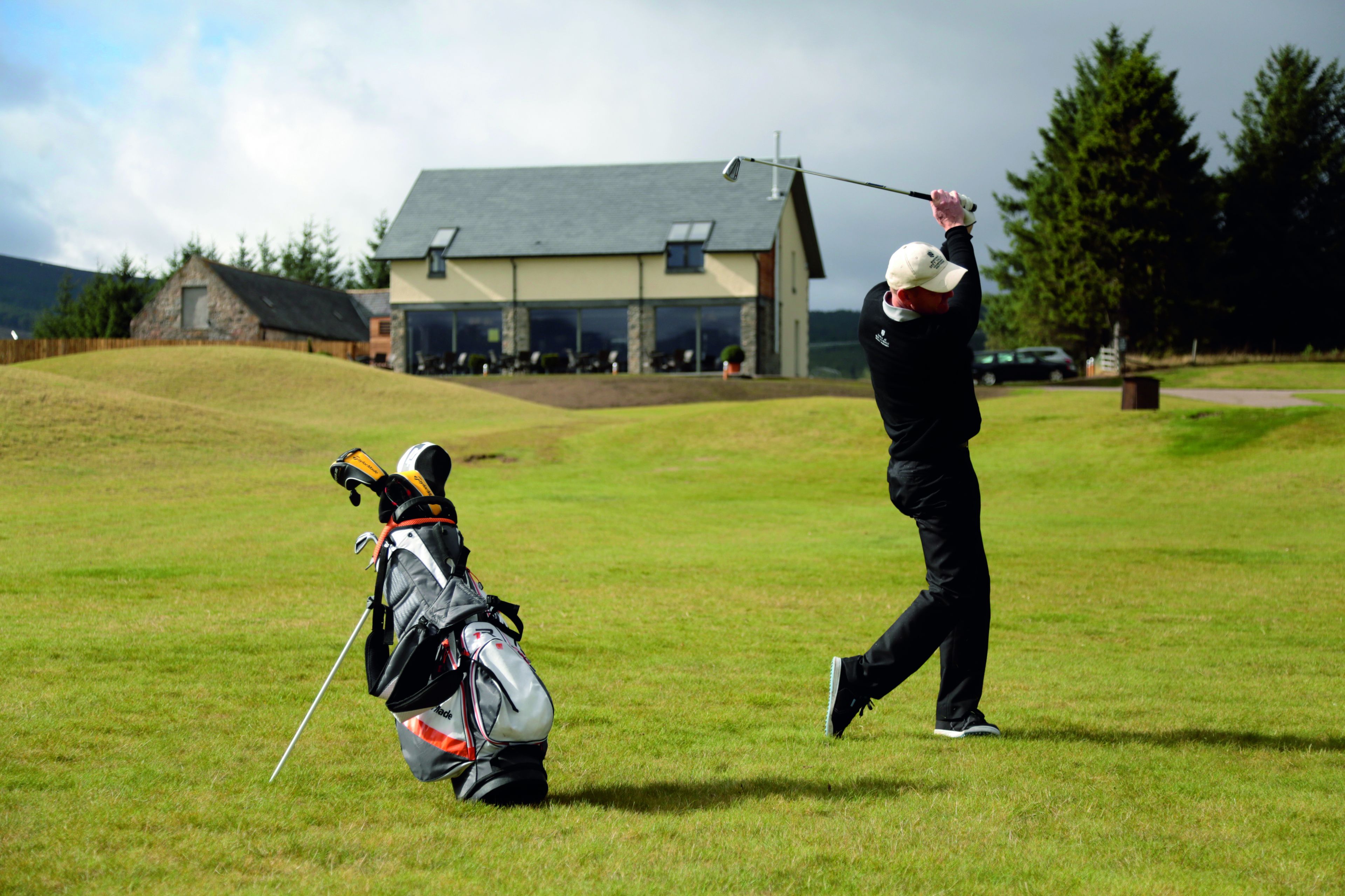 Un terrain de golf avec un club-house en arrière-plan.
