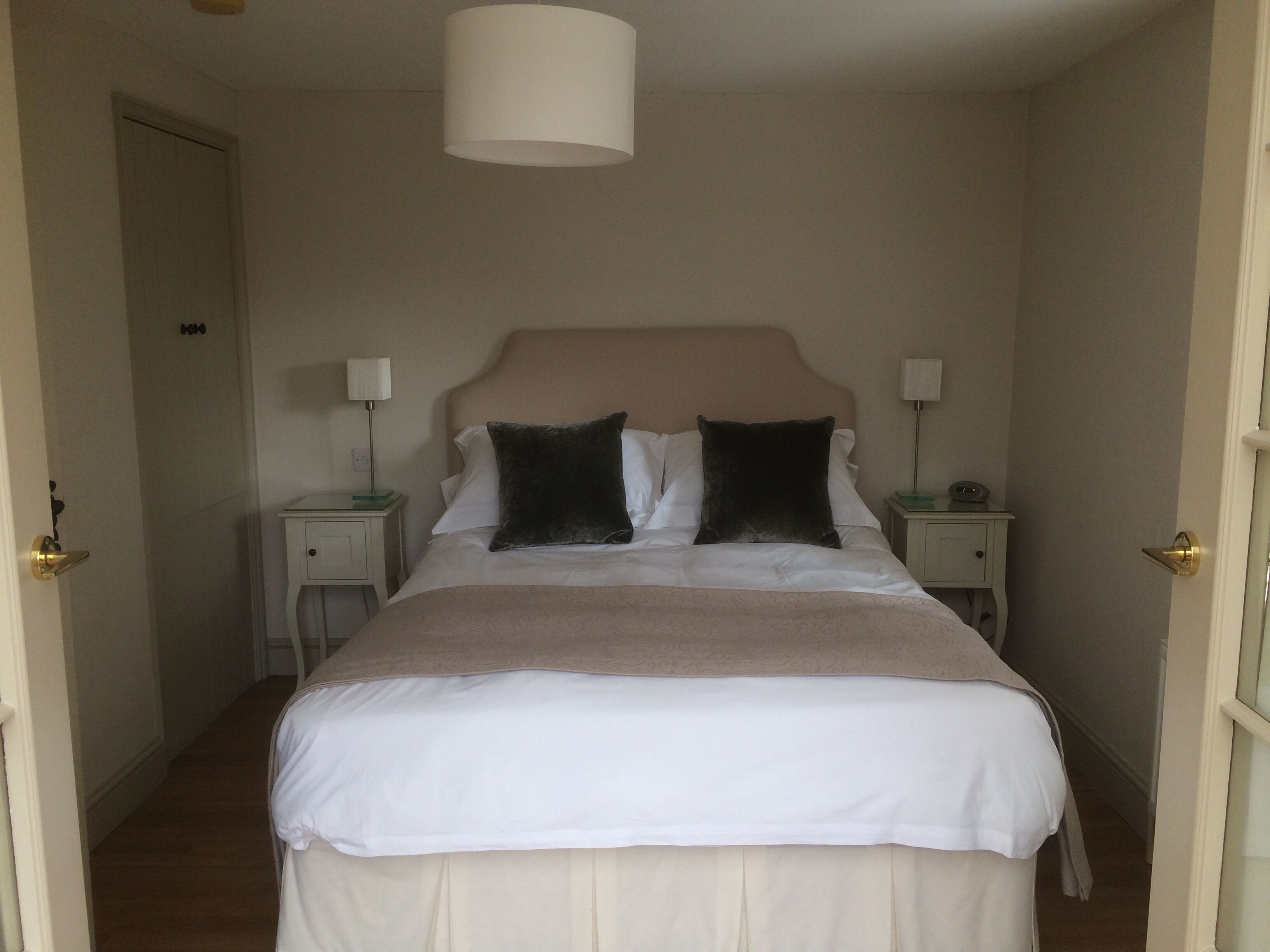 Ett hotellrum med en stor säng, två sängbord och en taklampa.