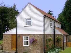 A two-story house with a brick foundation and white siding. - The Barn At Woodview (Tonbridge)