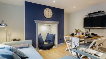 Un dormitorio moderno con cama, mesita de noche, lámpara y un reloj de pared.