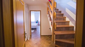 A hallway leading to a bedroom with a wooden staircase. - Jerry & Oli Apartments (Sibenik)