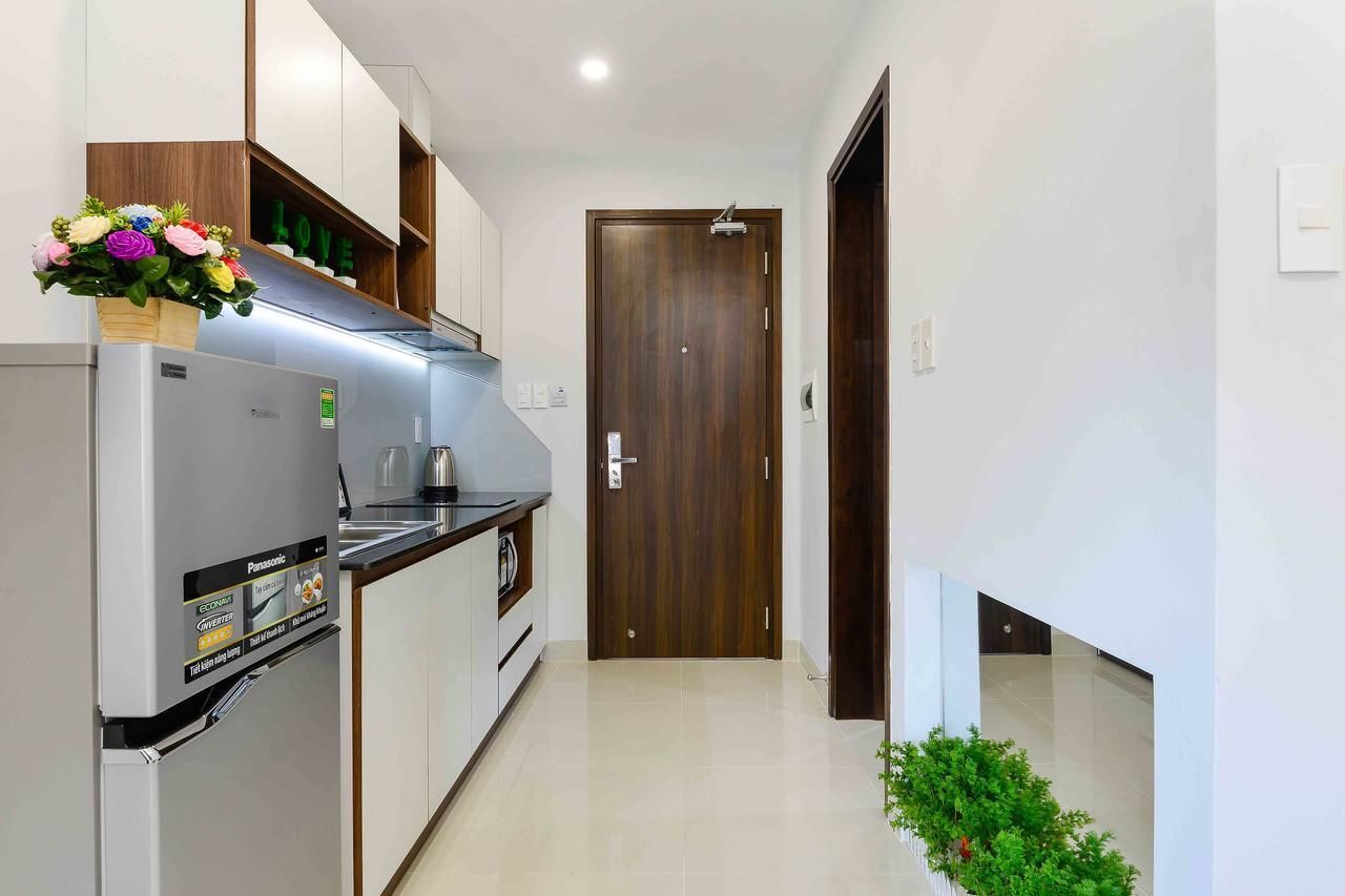 Eine moderne Küche mit Einbaukühlschrank, einem Holzkasten und einer kleinen Arbeitsplatte.