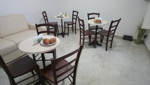 Un comedor con una mesa redonda, sillas y un sofá.