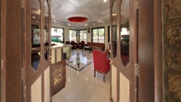 A spacious lobby with a high ceiling, a central seating area, and a large mirror reflecting the space. - Basilica Holiday Home (Mawal)