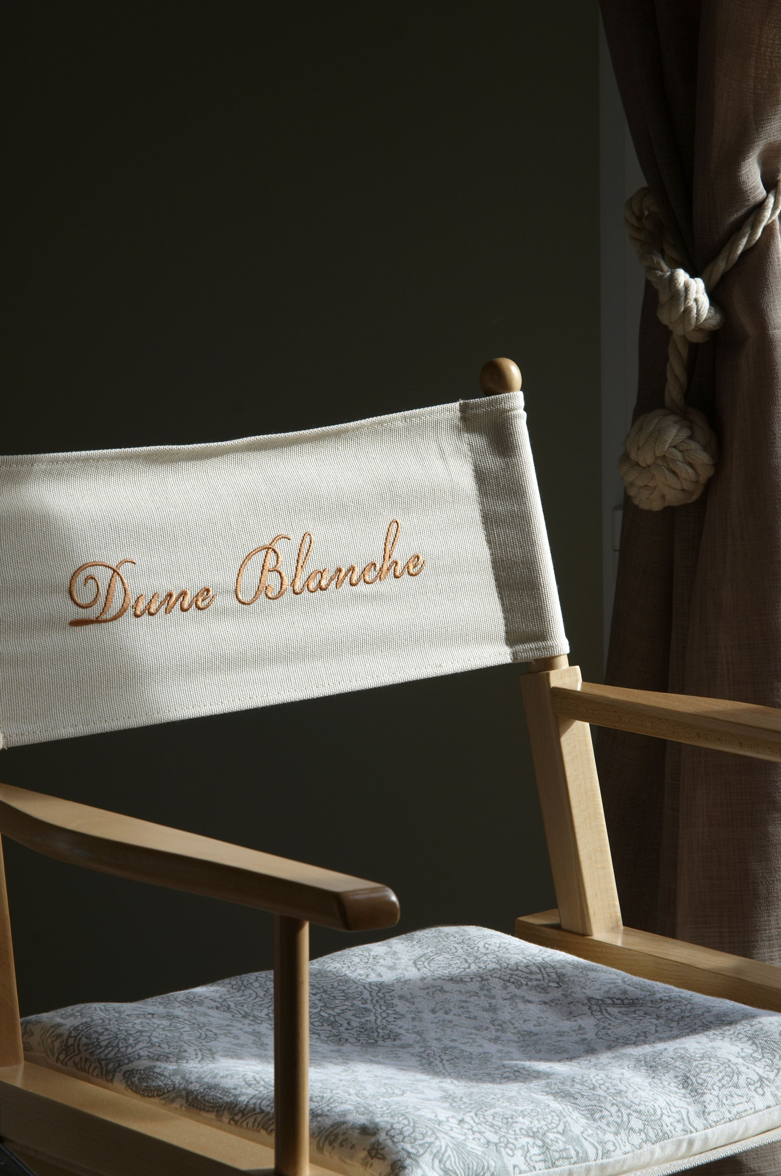 A chair with a headrest labeled "Dune Blanche" and a patterned cushion.
