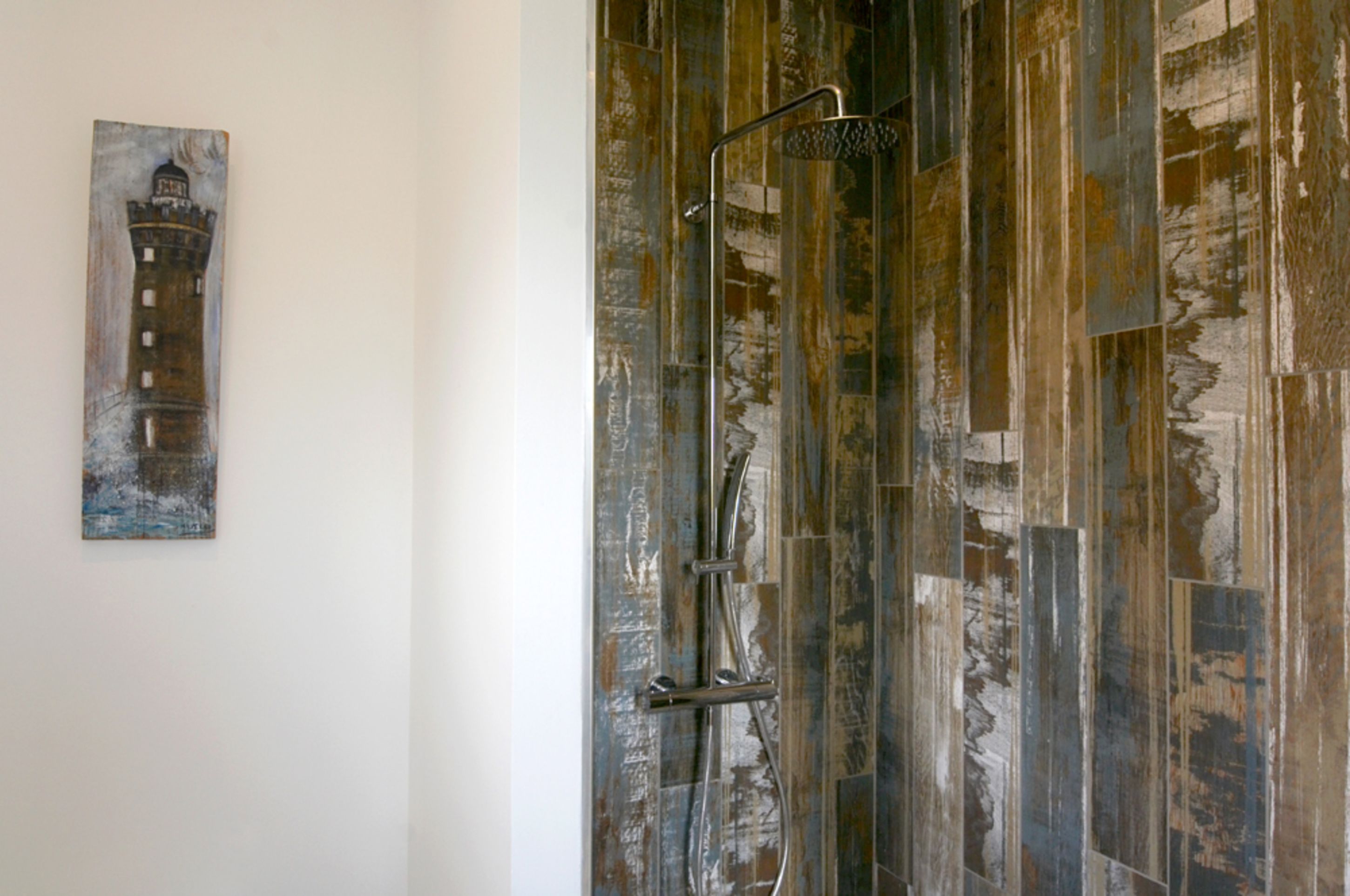 Une salle de bain avec un mur en bois rustique et une douche moderne.
