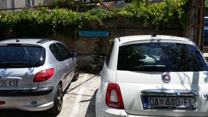 Two parked cars, a silver and a white Fiat, in a narrow street with a sign indicating parking for Jane & Nick. - Apartment Toma (Sibenik)