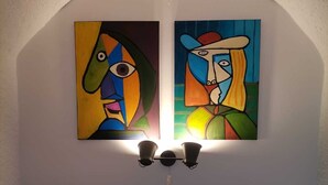 A bedroom with a bed, a headboard, and two paintings on the wall. - Apartment Toma (Sibenik)