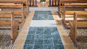 A church interior with wooden pews, a marble floor, and a central altar with a crucifix. - Azienda Agricola Le Colombare (Nogarole Rocca)