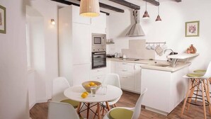 A modern kitchen with white cabinetry, a central island, and pendant lighting.