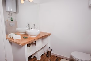 A modern bathroom with a wooden vanity, two white sinks, a mirror, and a toilet. - A&E Apartment - Near Cathedral of St James (Sibenik)