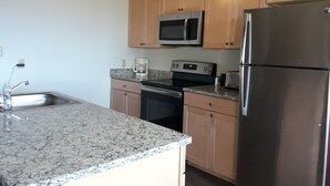 A kitchen with granite countertops, stainless steel appliances, wooden cabinets, and a ceiling fan. - Perfect For Large Families & Groups - Excellent Location (Snowshoe)