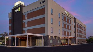 A multi-story hotel with a modern design, featuring a prominent 'Home 2 Suites by Hilton' sign, a covered entrance, and a parking lot. - Home2 Suites by Hilton Phoenix Airport South (Phoenix)