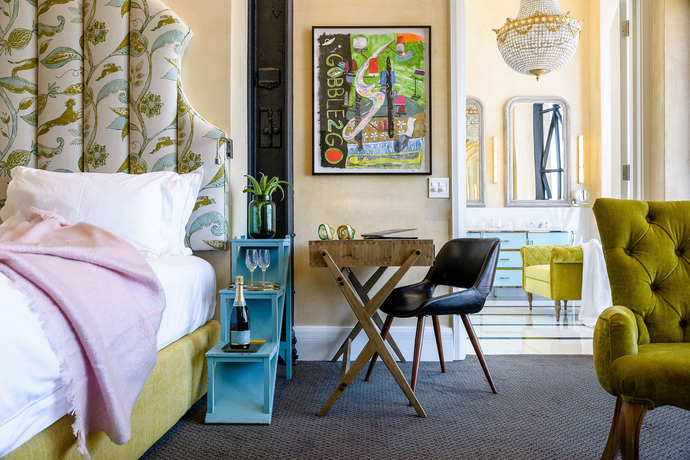 Quarto com cama, escrivaninha, cadeira e poltrona verde.
