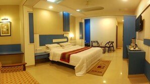 Una habitación de hotel con una cama, un sofá, un escritorio y un televisor.