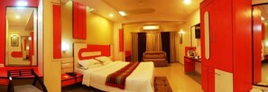 A hotel room with a bed, a desk, a chair, a wardrobe, and a bathroom. - Nayak Beach Resort (Puri)