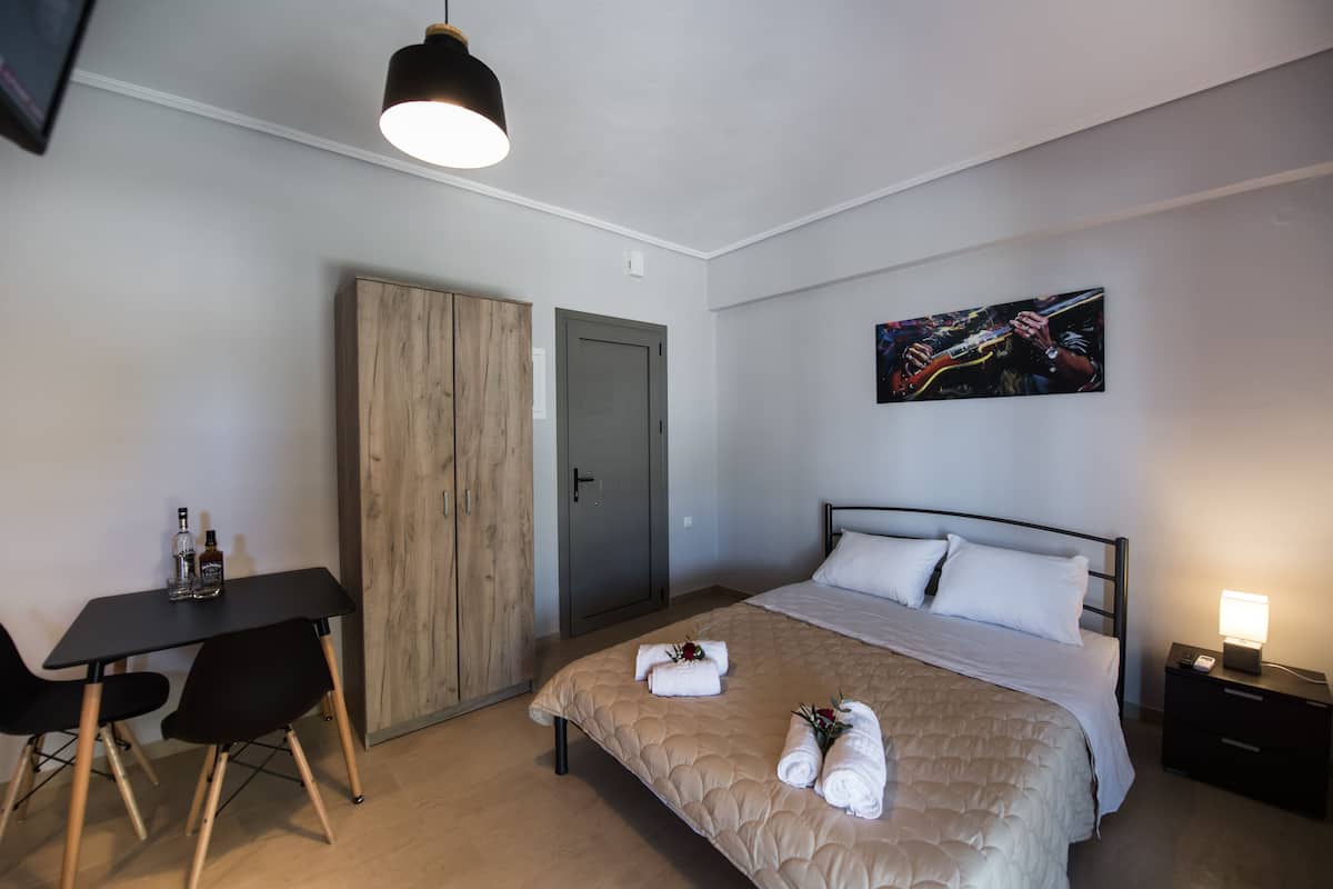 Ein Hotelzimmer mit einem Bett, einem Schreibtisch, einem Kleiderschrank und einem Bild an der Wand.