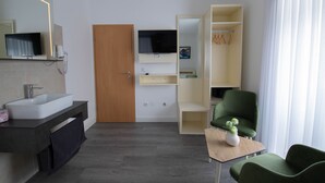 A modern bathroom with a sink, mirror, and television. - Heidepension (Bispingen)