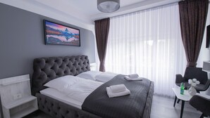 A bedroom with a large bed, a bedside table, a chair, and a window with curtains. - Heidepension (Bispingen)
