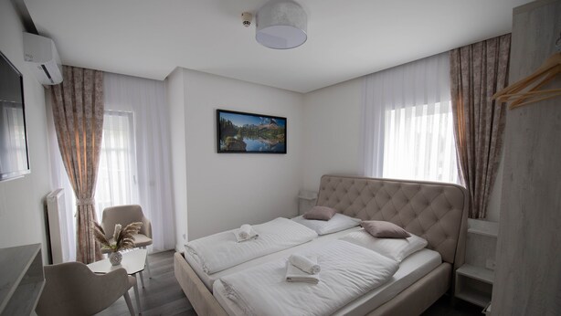 A modern bedroom with a large bed, a desk, and a chair.