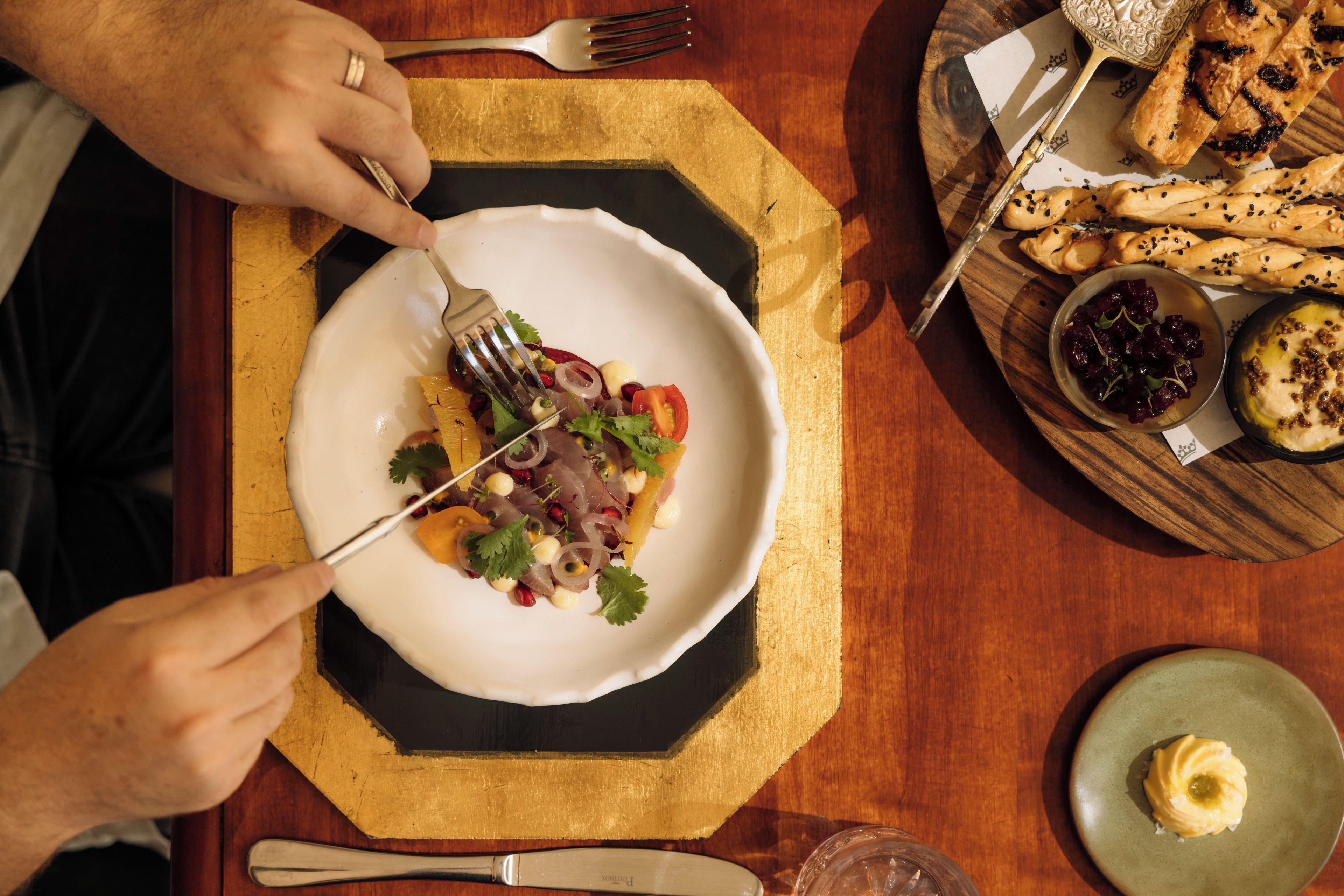 Una mesa de comedor con un plato de comida, un tenedor y un cuchillo.