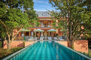 Un hôtel doté d’une piscine, d’un espace extérieur aménagé et d’un patio couvert.