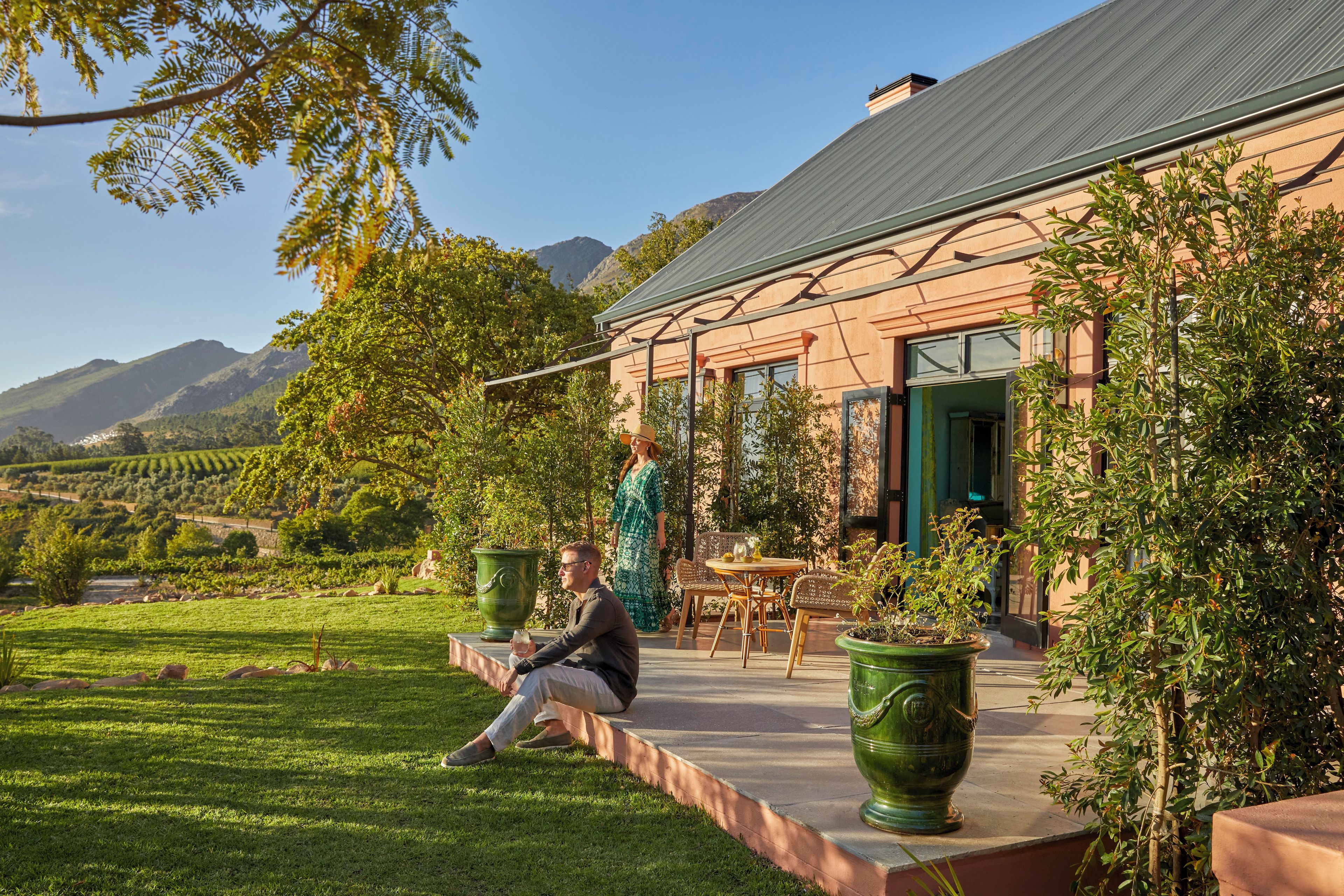 A building with a patio area, outdoor seating, and a view of a vineyard.