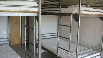 A bunk bed room with metal railings and a wooden door.