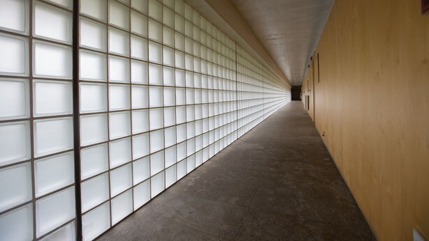 A corridor with a patterned wall and a plain floor, leading to a door at the end. - HI Ponte de Lima - Pousada de Juventude - Hostel (Ponte de Lima)