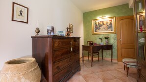 A room with a wooden dresser, a table with a vase, and a chair. - Sicily's View (Mascalucia)