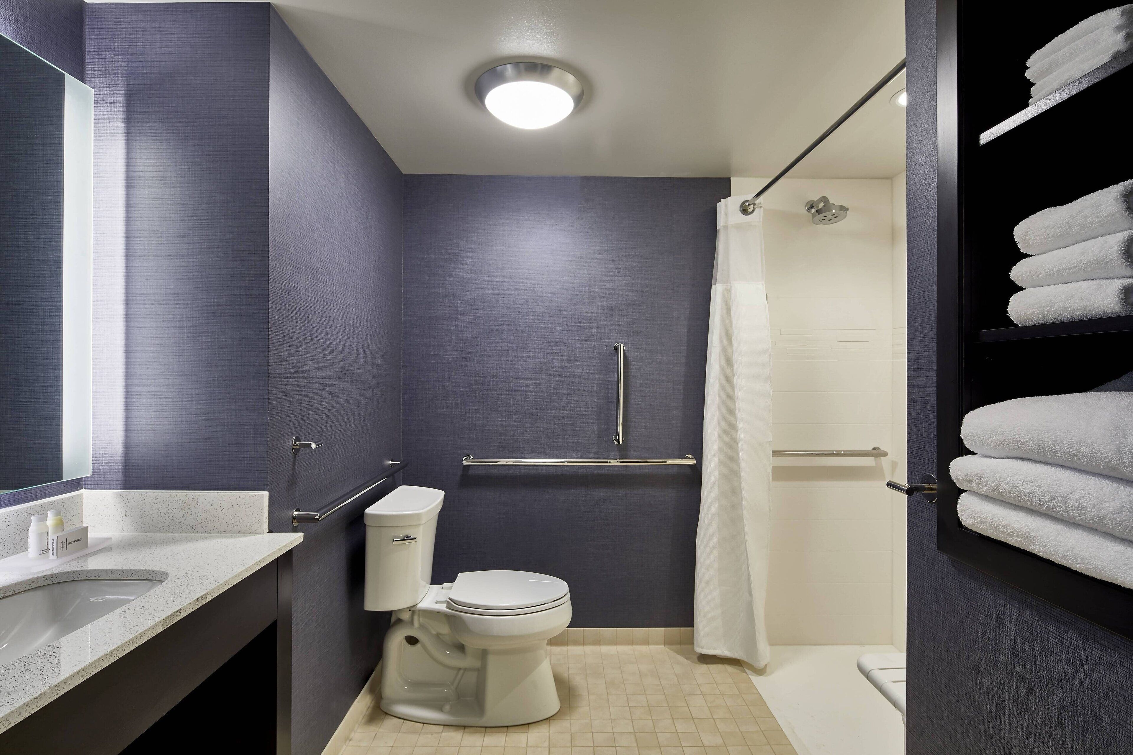 Un baño moderno con inodoro, lavamanos y ducha.