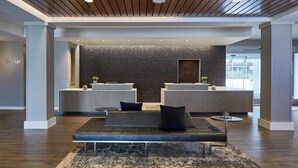 A modern reception area with a reception desk, seating area, and a brick wall. - Residence Inn by Marriott Cleveland University Circle/Medical Center (Cleveland)