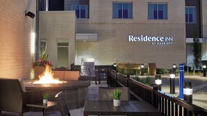 A patio area with a fire pit, outdoor seating, and a view of the hotel entrance. - Residence Inn by Marriott Cleveland University Circle/Medical Center (Cleveland)