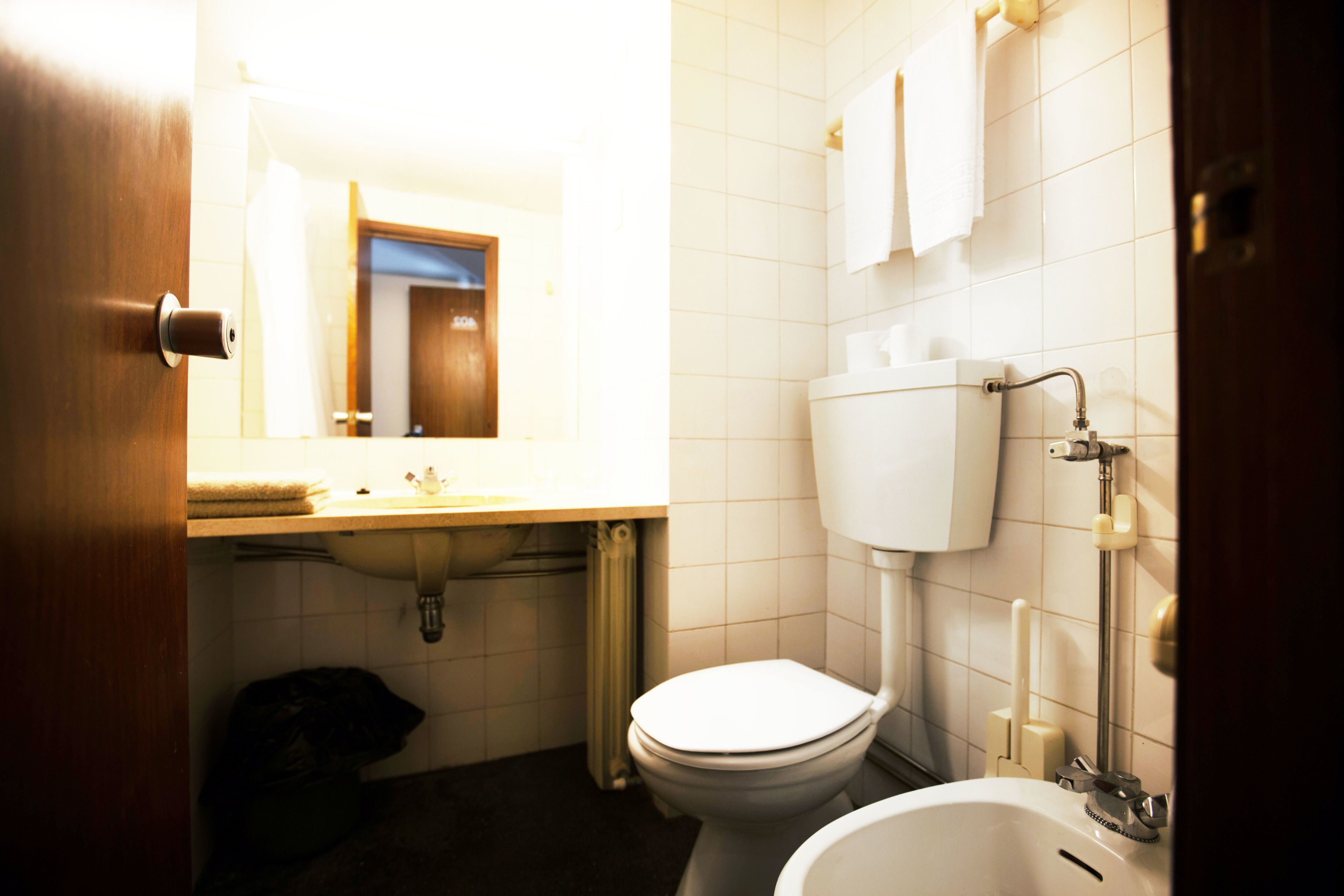 Une petite salle de bain avec des toilettes, un lavabo et une baignoire.