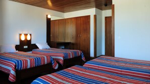 A room with two beds, wooden cabinets, and a mirror. - HI Sao Pedro do Sul Pousada de Juventude - Hostel (Sao Pedro do Sul)