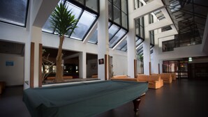 A spacious indoor area with a pool table, seating, and skylights. - HI Sao Pedro do Sul Pousada de Juventude - Hostel (Sao Pedro do Sul)