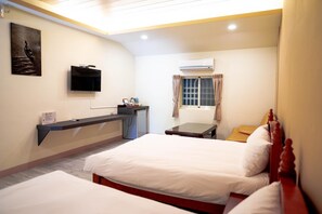 A hotel room with a bed, a desk, a TV, and an air conditioning unit. - forest (Manzhou)