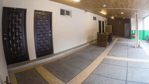 Un couloir avec deux portes, un plafond en bois et un sol carrelé.